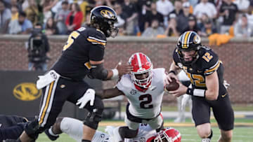 Oct 1, 2022; Columbia, Missouri, USA; Missouri Tigers quarterback Brady Cook (12) runs as Georgia Bulldogs linebacker Smael Mondon Jr. (2) attempts to make a tackle during the first half at Faurot Field at Memorial Stadium. Mandatory Credit: Denny Medley-USA TODAY Sports
