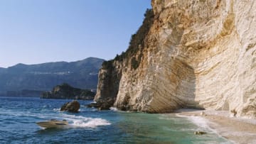 A speedboat skims across the water of the Ionian sea close to a deserted beach cove near the resort of Paleokastritsa, on the Greek Island of Corfu, Greece, in April 1996. (Photo by Bryn Colton/Getty Images)