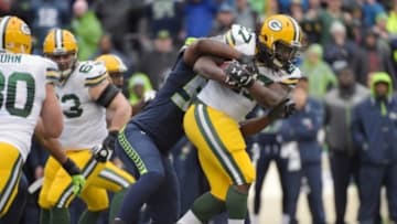 Jan 18, 2015; Seattle, WA, USA; Green Bay Packers running back Eddie Lacy (27) carries the ball as he is tackled by Seattle Seahawks defensive end Cliff Avril (56) during the fourth quarter in the NFC Championship Game at CenturyLink Field. Mandatory Credit: Kirby Lee-USA TODAY Sports