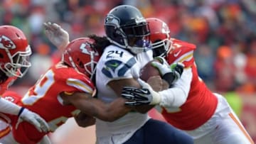 Nov 16, 2014; Kansas City, MO, USA; Seattle Seahawks running back Marshawn Lynch (24) is tackled by Kansas City Chiefs outside linebacker Tamba Hali (91) and strong safety Eric Berry (29) during the first half at Arrowhead Stadium. Mandatory Credit: Denny Medley-USA TODAY Sports