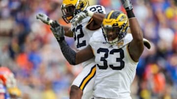 Jan 1, 2016; Orlando, FL, USA; Michigan Wolverines safety Jarrod Wilson (22) and defensive end Taco Charlton (33) celebrate his interception against the Florida Gators during the second quarter in the 2016 Citrus Bowl at Orlando Citrus Bowl Stadium. Mandatory Credit: Jim Dedmon-USA TODAY Sports
