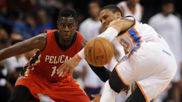 Dec 21, 2014; Oklahoma City, OK, USA; New Orleans Pelicans guard Jrue Holiday (11) knocks the ball out of the hands of Oklahoma City Thunder guard Russell Westbrook (0) during the fourth quarter at Chesapeake Energy Arena. Mandatory Credit: Mark D. Smith-USA TODAY Sports