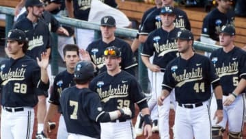 Jun 25, 2014; Omaha, NE, USA; Teammates congratulate Vanderbilt Commodores infielder Dansby Swanson (7) after scoring the first run of the game in the first inning during game three of the College World Series Finals against the Virginia Cavaliers at TD Ameritrade Park Omaha. Mandatory Credit: Steven Branscombe-USA TODAY Sports