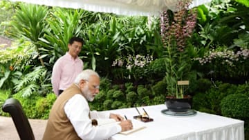 SINGAPORE - JUNE 02: Indian Prime Minister Narendra Modi (front) signs the guest book as Singapore Minister for Education and Second Minster for Ministry of Defence, Ong Ye Kung looks on during an orchid naming ceremony at the National Orchid Gardens on June 2, 2018 in Singapore. Narendra Modi is on a three day official visit to Singapore. (Photo by Suhaimi Abdullah/Getty Images)