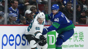 VANCOUVER, BC - JANUARY 18: Elias Pettersson #40 of the Vancouver Canucks and Kevin Labanc #62 of the San Jose Sharks battle for a loose puck during their NHL game at Rogers Arena January 18, 2020 in Vancouver, British Columbia, Canada. (Photo by Jeff Vinnick/NHLI via Getty Images)"n