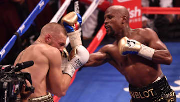 LAS VEGAS, NV - AUGUST 26: (R-L) Floyd Mayweather Jr. punches Conor McGregor in their super welterweight boxing match at T-Mobile Arena on August 26, 2017 in Las Vegas, Nevada. Mayweather won by 10th-round TKO. (Photo by Jeff Bottari/Zuffa LLC/Zuffa LLC via Getty Images)