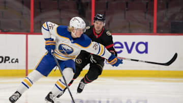 Jan 25, 2022; Ottawa, Ontario, CAN; Buffalo Sabres defenseman Rasmus Dahlin (26) skates with the puck in front of Ottawa Senators center Josh Norris (9) in the second period at the Canadian Tire Centre. Mandatory Credit: Marc DesRosiers-USA TODAY Sports
