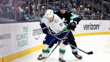 SEATTLE, WASHINGTON - JANUARY 01: Adam Larsson #6 of the Seattle Kraken defends Nils Hoglander #21 of the Vancouver Canucks during the first period at Climate Pledge Arena on January 01, 2022 in Seattle, Washington. (Photo by Steph Chambers/Getty Images)