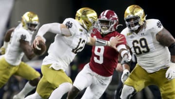Jan 1, 2021; Arlington, TX, USA; Notre Dame quarterback Ian Book (12) scrambles away from pressure by Alabama defensive back Jordan Battle (9) Friday, Jan. 1, 2021 in the College Football Playoff Semifinal hosted by the Rose Bowl in AT&T Stadium. Mandatory Credit: Gary Cosby-USA TODAY Sports
