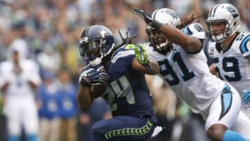 Oct 18, 2015; Seattle, WA, USA; Seattle Seahawks running back Marshawn Lynch (24) is tackled by Carolina Panthers defensive end Ryan Delaire (91) during the fourth quarter at CenturyLink Field. Mandatory Credit: Joe Nicholson-USA TODAY Sports