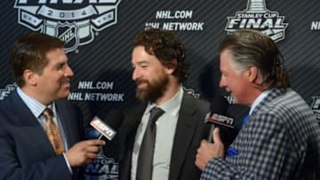 Jun 4, 2014; Los Angeles, CA, USA; Los Angeles Kings right wing Justin Williams (middle) is interviewed by ESPN reporters Barry Melrose (right) and Steve Levy (left) after game one of the 2014 Stanley Cup Final against the New York Rangers at Staples Center. Mandatory Credit: Kirby Lee-USA TODAY Sports