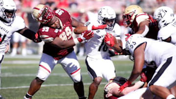LOUISVILLE, KENTUCKY - OCTOBER 05: TJ Rayam #99 of the Boston College Eagles loses his helmet while tackling Javian Hawkins #10 of the Louisville Cardinals during the fourth quarter at Cardinal Stadium on October 05, 2019 in Louisville, Kentucky. (Photo by Justin Casterline/Getty Images)