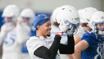 Kansas senior cornerback Kwinton Lassiter (8) smiles while putting his helmat on during Tuesday's practice inside the Kansas Indoor Practice Facility.