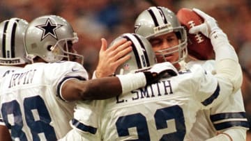 Emmitt Smith of the Dallas Cowboys receives congratulations from teammates Michael Irvin (L) and Troy Aikman (R) after breaking the NFL career touchdown record against the Washington Redskins at Texas Stadium 27 December in Irving, Texas. AFP PHOTO/Paul BUCK (Photo by PAUL BUCK / AFP) (Photo by PAUL BUCK/AFP via Getty Images)