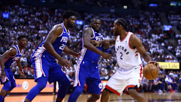 TORONTO, ON - APRIL 29: Kawhi Leonard #2 of the Toronto Raptors dribbles the ball as Joel Embiid #21 and James Ennis III #11 of the Philadelphia 76ers defend during Game Two of the second round of the 2019 NBA Playoffs at Scotiabank Arena on April 29, 2019 in Toronto, Canada. NOTE TO USER: User expressly acknowledges and agrees that, by downloading and or using this photograph, User is consenting to the terms and conditions of the Getty Images License Agreement. (Photo by Vaughn Ridley/Getty Images)