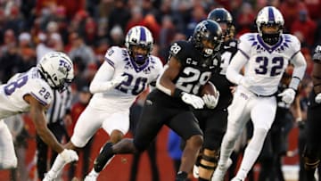 AMES, IA - NOVEMBER 26: Running back Breece Hall #28 of the Iowa State Cyclones drives the ball for a touchdown past safety Nook Bradford #28, safety La'Kendrick Van Zandt #20, and defensive end Ochaun Mathis #32 of the TCU Horned Frogs in the first half of play at Jack Trice Stadium on November 26, 2021 in Ames, Iowa. (Photo by David Purdy/Getty Images)