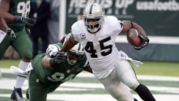 Dec 8, 2013; East Rutherford, NJ, USA; Oakland Raiders fullback Marcel Reece (45) is defended by New York Jets defensive lineman Damon Harrison (94) in the first half at MetLife Stadium. Mandatory Credit: Kirby Lee-USA TODAY Sports