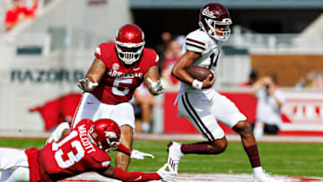 FAYETTEVILLE, ARKANSAS - OCTOBER 21: Mike Wright #14 of the Mississippi State Bulldogs runs the ball in the second half and avoids the tackle of Alfahiym Walcott #13 of the Arkansas Razorbacks at Donald W. Reynolds Razorback Stadium on October 21, 2023 in Fayetteville, Arkansas. The Bulldogs defeated the Razorbacks 7-3. (Photo by Wesley Hitt/Getty Images)