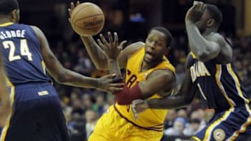 Jan 5, 2014; Cleveland, OH, USA; Cleveland Cavaliers shooting guard C.J. Miles (center) drives between Indiana Pacers small forward Paul George (24) and shooting guard Lance Stephenson (1) in the first quarter at Quicken Loans Arena. Mandatory Credit: David Richard-USA TODAY Sports