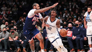 Jan 3, 2022; Brooklyn, New York, USA; Memphis Grizzlies guard Ja Morant (12) drives past Brooklyn Nets forward James Johnson (16) in the third quarter at Barclays Center. Mandatory Credit: Wendell Cruz-USA TODAY Sports
