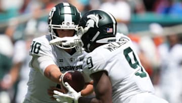 Sep 18, 2021; Miami Gardens, Florida, USA; Michigan State Spartans quarterback Payton Thorne (10) hands the ball to running back Kenneth Walker III (9) during the first half against the Miami Hurricanes at Hard Rock Stadium. Mandatory Credit: Jasen Vinlove-USA TODAY Sports