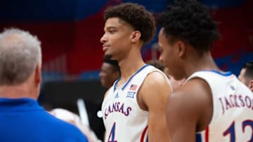 Kansas junior forward Justice Cross (4) hangs with players before a group photo at media day inside Allen Fieldhouse Wednesday.