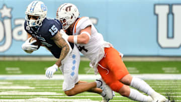 CHAPEL HILL, NORTH CAROLINA - OCTOBER 10: Dax Hollifield #4 of the Virginia Tech Hokies tackles Beau Corrales #15 of the North Carolina Tar Heels during their game at Kenan Stadium on October 10, 2020 in Chapel Hill, North Carolina. North Carolina won 56-45. (Photo by Grant Halverson/Getty Images)