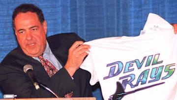 PALM BEACH, FL - MARCH 9: Vince Naimoli, owner of the "Tampa Bay Devil Rays" displays his new team's jersey to reporters 09 March in Palm Beach, Florida. Members of the Major League Expansion Committee announced Naimoli's team would be one of two new expansion teams approved for baseball. The new team will begin playing in the 1998 season. (COLOR KEY: Background is blue.) AFP PHOTO (Photo credit should read DOUG COLLIER/AFP/Getty Images)