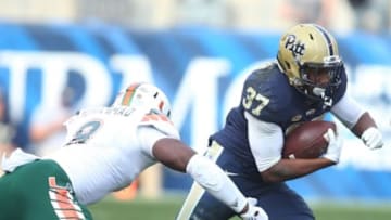Nov 27, 2015; Pittsburgh, PA, USA; Pittsburgh Panthers running back Qadree Ollison (37) rushes the ball against Miami Hurricanes defensive lineman Al-Quadin Muhammad (8) during the third quarter at Heinz Field. Miami won 29-24. Mandatory Credit: Charles LeClaire-USA TODAY Sports
