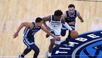MINNEAPOLIS, MINNESOTA - DECEMBER 12: Anthony Edwards #1 of the Minnesota Timberwolves dribbles the ball against Desmond Bane #22 and Tyus Jones #21 of the Memphis Grizzlies during the first quarter of the preseason game at Target Center on December 12, 2020 in Minneapolis, Minnesota. NOTE TO USER: User expressly acknowledges and agrees that, by downloading and or using this Photograph, user is consenting to the terms and conditions of the Getty Images License Agreement. (Photo by Hannah Foslien/Getty Images)