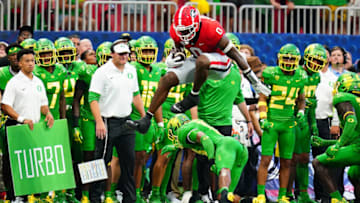 Georgia Bulldogs tight end Darnell Washington (0) hurdles Oregon Ducks defensive back Bryan Addison (13) during the Chick-fil-A kickoff game at Mercedes-Benz Stadium. Mandatory Credit: John David Mercer-USA TODAY Sports