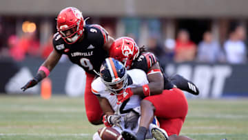 LOUISVILLE, KENTUCKY - OCTOBER 26: C.J. Avery #9 and Boosie Whitlow #49 of the Louisville Cardinals combine to force a fumble by Joe Reed #2 of the Virginia Cavaliers on October 26, 2019 in Louisville, Kentucky. (Photo by Andy Lyons/Getty Images)