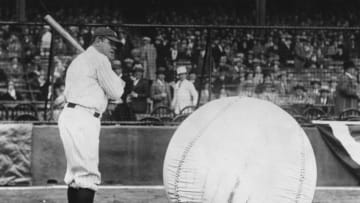 April 1927: Baseball player Babe Ruth (George Herman Ruth, 1895 - 1948) taking a swipe at an enormous ball. (Photo by Fox Photos/Getty Images)