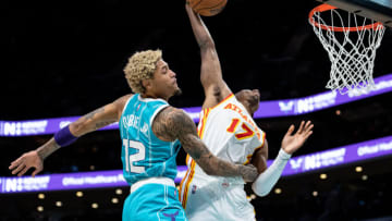 CHARLOTTE, NORTH CAROLINA - MARCH 16: Onyeka Okongwu #17 of the Atlanta Hawks dunks the ball over Kelly Oubre Jr. #12 of the Charlotte Hornets in the fourth quarter during their game at Spectrum Center on March 16, 2022 in Charlotte, North Carolina. NOTE TO USER: User expressly acknowledges and agrees that, by downloading and or using this photograph, User is consenting to the terms and conditions of the Getty Images License Agreement. (Photo by Jacob Kupferman/Getty Images)