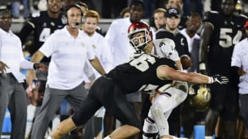 ORLANDO, FLORIDA - NOVEMBER 17: Pat Jasinski #56 of the UCF Knights knocks the ball loose from Desmond Ridder #9 of the Cincinnati Bearcats during the third quarter on November 17, 2018 at Spectrum Stadium in Orlando, Florida. (Photo by Julio Aguilar/Getty Images)