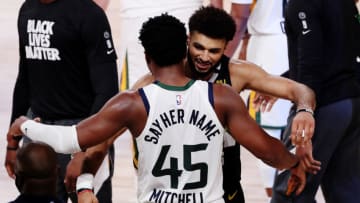 LAKE BUENA VISTA, FLORIDA - SEPTEMBER 01: Donovan Mitchell #45 of the Utah Jazz hugs Jamal Murray #27 of the Denver Nuggets (Photo by Mike Ehrmann/Getty Images)