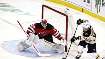 NEWARK, NEW JERSEY - JANUARY 14: Mackenzie Blackwood #29 of the New Jersey Devils stops a shot as Brad Marchand #63 of the Boston Bruins passes in the first period during the home opening game at Prudential Center on January 14, 2021 in Newark, New Jersey. (Photo by Elsa/Getty Images)
