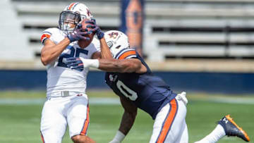 Auburn football wide receiver Caylin Newton (25) catches a pass as he is tackled by Auburn linebacker Owen Pappoe (0) during Auburn football A-Day spring game at Jordan-Hare Stadium in Auburn, Ala., on Saturday, April 17, 2021.