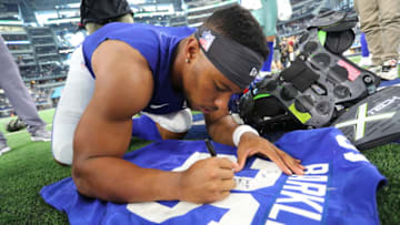 ARLINGTON, TEXAS - SEPTEMBER 08: Saquon Barkley #26 of the New York Giants signs his jersey to trade with Sean Lee of the Dallas Cowboys after the Cowboys 35-17 win at AT&T Stadium on September 08, 2019 in Arlington, Texas. (Photo by Richard Rodriguez/Getty Images)