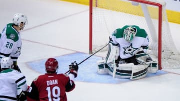 Mar 24, 2016; Glendale, AZ, USA; Dallas Stars goalie Kari Lehtonen (32) makes a save in front of Arizona Coyotes right wing Shane Doan (19) and defenseman Stephen Johns (28) in the first period at Gila River Arena. Mandatory Credit: Matt Kartozian-USA TODAY Sports