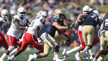 Tai Lavatai of the Navy Midshipmen options the ball in the first half against the Cincinnati Bearcats. Getty Images.