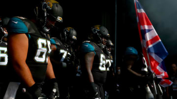 LONDON, ENGLAND - OCTOBER 02: Sen'Derrick Marks #99 of the Jacksonville Jaguars holds a Union Jack flag as he prepares to run out with Brandon Linder #65 and Kelvin Beachum #68 of the Jacksonville Jaguars for the NFL game between Indianapolis Colts and Jacksonville Jaguars at Wembley Stadium on October 2, 2016 in London, England. (Photo by Dan Istitene/Getty Images)