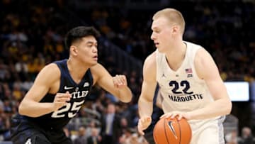 MILWAUKEE, WISCONSIN - FEBRUARY 20: Joey Hauser #22 of the Marquette Golden Eagles dribbles the ball while being guarded by Christian David #25 of the Butler Bulldogs in the first half at the Fiserv Forum on February 20, 2019 in Milwaukee, Wisconsin. (Photo by Dylan Buell/Getty Images)