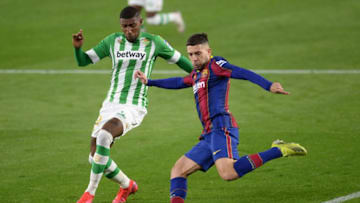Real Betis' Brazilian defender Emerson Royal challenges Barcelona's Spanish defender Jordi Alba (R).(Photo by CRISTINA QUICLER/AFP via Getty Images)