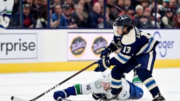 COLUMBUS, OHIO - OCTOBER 18: Bo Horvat #53 of the Vancouver Canucks falls to the ice as he battles for the puck against Johnny Gaudreau #13 of the Columbus Blue Jackets during the third period at Nationwide Arena on October 18, 2022 in Columbus, Ohio. (Photo by Emilee Chinn/Getty Images)