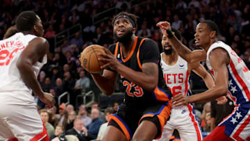 Mar 1, 2023; New York, New York, USA; New York Knicks center Mitchell Robinson (23) looks to shoot the ball against Brooklyn Nets forward Dorian Finney-Smith (28) and guard Spencer Dinwiddie (26) and center Nic Claxton (33) during the third quarter at Madison Square Garden. Mandatory Credit: Brad Penner-USA TODAY Sports