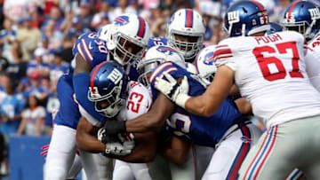 Oct 4, 2015; Orchard Park, NY, USA; Buffalo Bills strong safety Bacarri Rambo (30) and Buffalo Bills defensive end Jerry Hughes (55) tackle New York Giants running back Rashad Jennings (23) as he runs the ball during the second half at Ralph Wilson Stadium. Giants beat the Bills 24 to 10. Mandatory Credit: Timothy T. Ludwig-USA TODAY Sports