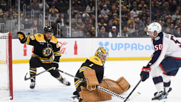 Dec 17, 2022; Boston, Massachusetts, USA; Columbus Blue Jackets left wing Eric Robinson (50) tries to gain control of the puck in front of Boston Bruins goaltender Jeremy Swayman (1) during the second period at TD Garden. Mandatory Credit: Bob DeChiara-USA TODAY Sports