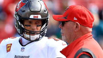 TAMPA, FLORIDA - JANUARY 16: Tom Brady #12 of the Tampa Bay Buccaneers talks with head coach Bruce Arians prior to the NFC Wild Card Playoff game against the Philadelphia Eagles at Raymond James Stadium on January 16, 2022 in Tampa, Florida. (Photo by Mike Ehrmann/Getty Images)