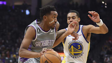 SACRAMENTO, CALIFORNIA - NOVEMBER 13: Malik Monk #0 of the Sacramento Kings drives to the basket against Jordan Poole #3 of the Golden State Warriors in the first quarter at Golden 1 Center on November 13, 2022 in Sacramento, California. NOTE TO USER: User expressly acknowledges and agrees that, by downloading and/or using this photograph, User is consenting to the terms and conditions of the Getty Images License Agreement. (Photo by Lachlan Cunningham/Getty Images)